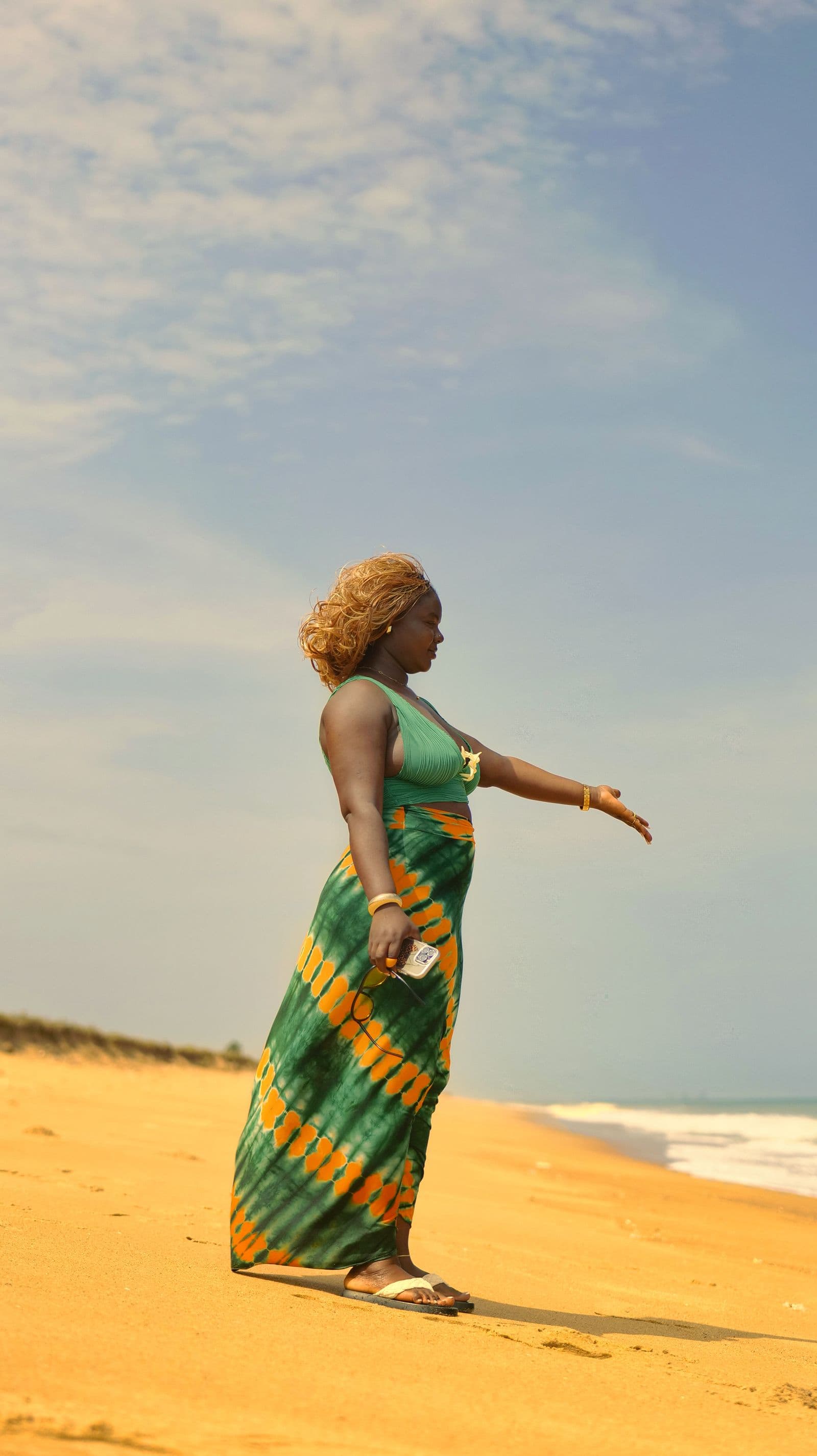 Une femme en robe colorée sur une plage ensoleillée